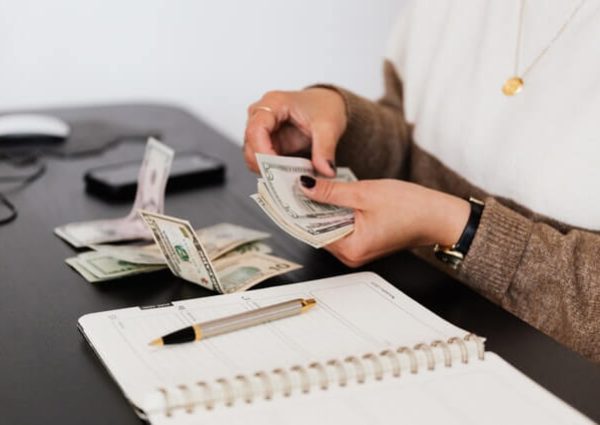 crop-payroll-clerk-counting-money-while-sitting-at-table